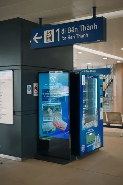 Inside Ben Thanh metro station with signage and vending machine.