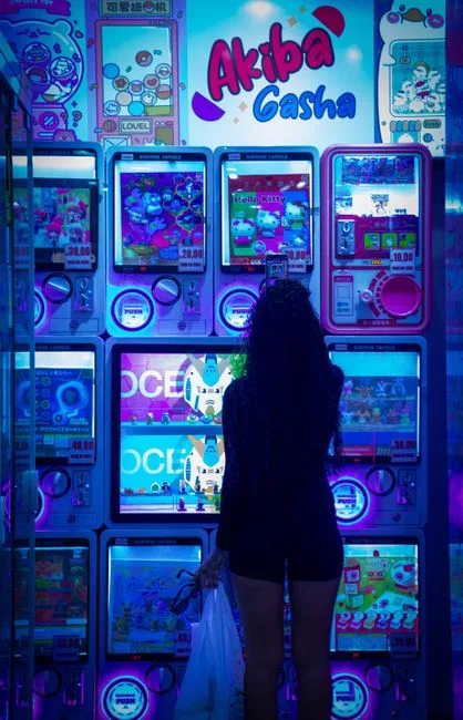 Silhouette of a woman in an arcade surrounded by illuminated gaming machines.