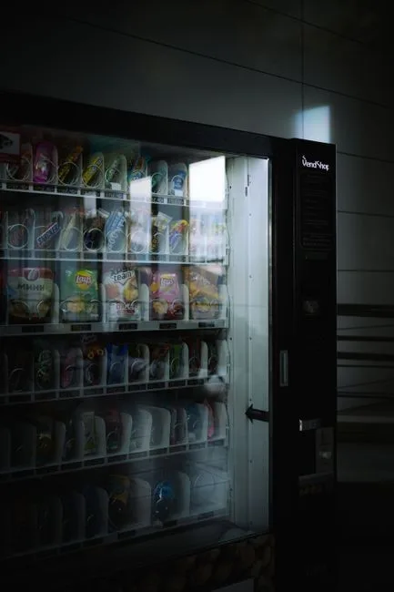 A vending machine indoors with snacks and drinks in a dimly lit environment, creating a moody atmosphere.