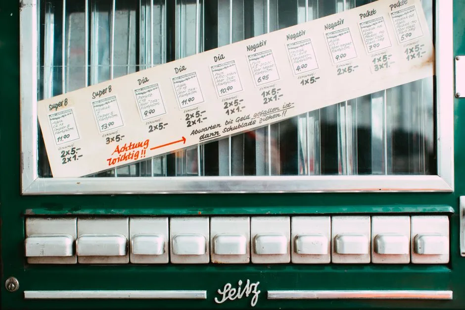 Vintage vending machine featuring German instructions and multiple white buttons.