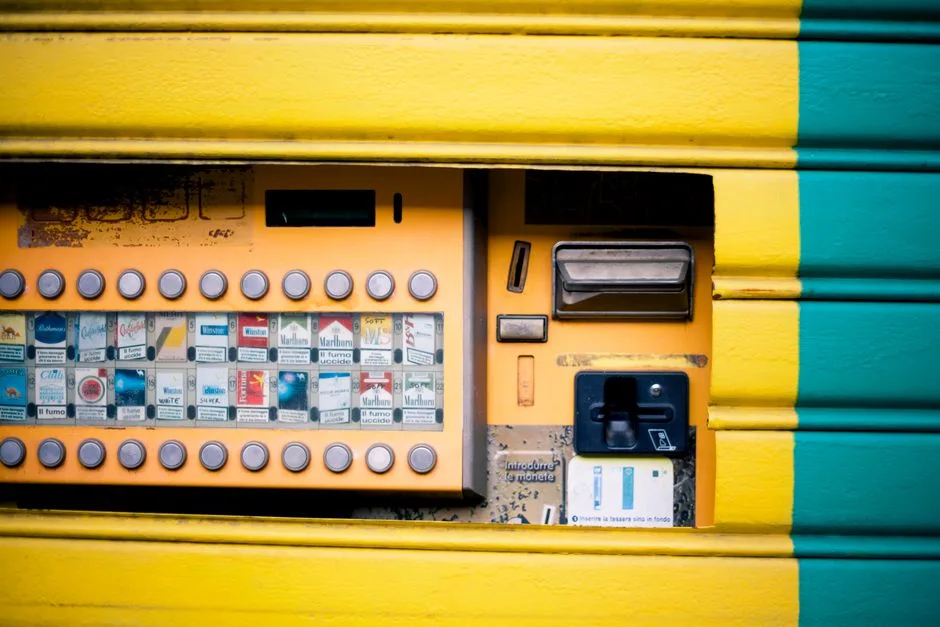 Detailed view of a vibrant yellow and green cigarette vending machine interface.