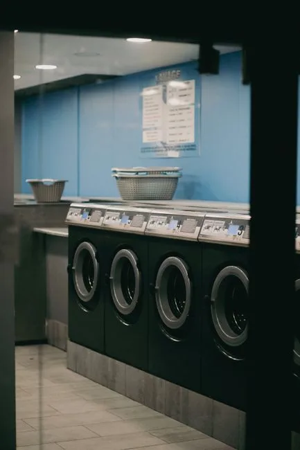 Interior view of a modern laundromat with multiple washing machines lined up.