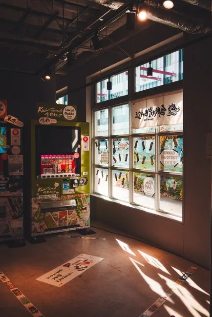 Interior of a Tokyo shop with a vending machine and sunlight filtering through windows.