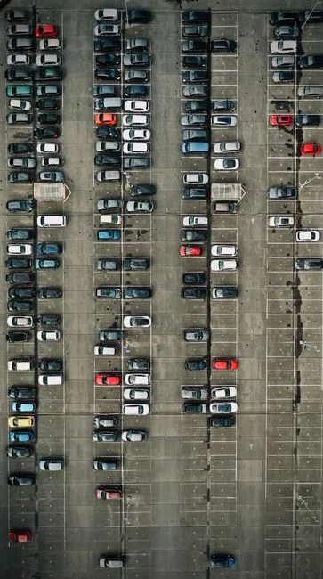 Top-down view of a busy parking lot with cars in Brugge, Belgium.
