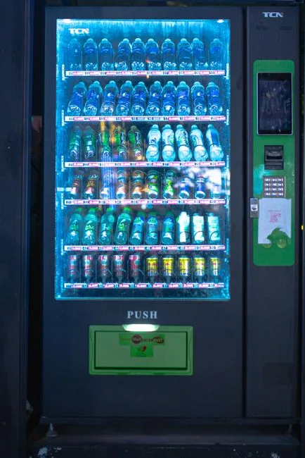 A brightly lit vending machine displaying assorted beverages at night, capturing urban convenience.