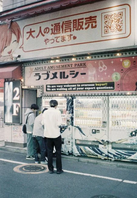 People gathering outside an amusement park in Shinjuku, Tokyo at night.