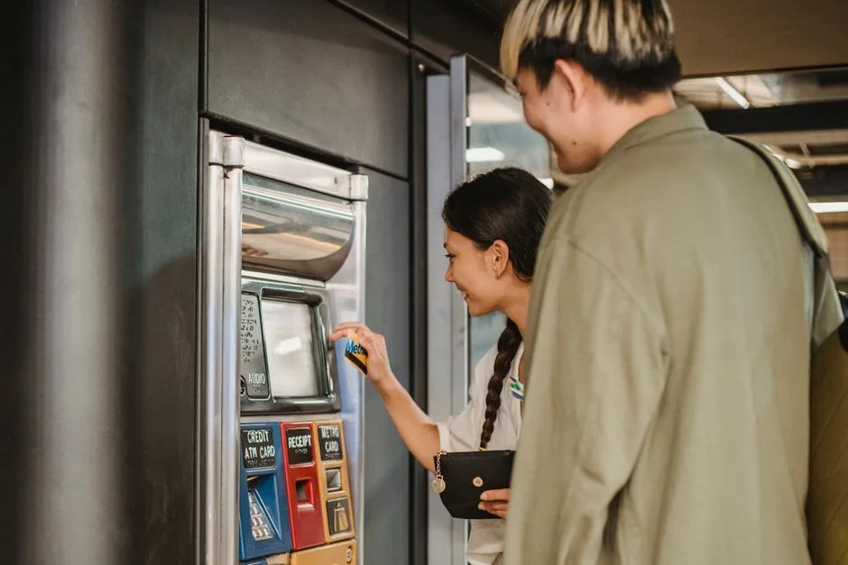Positive couple in casual clothes using ticket vending machine in underground or railway station