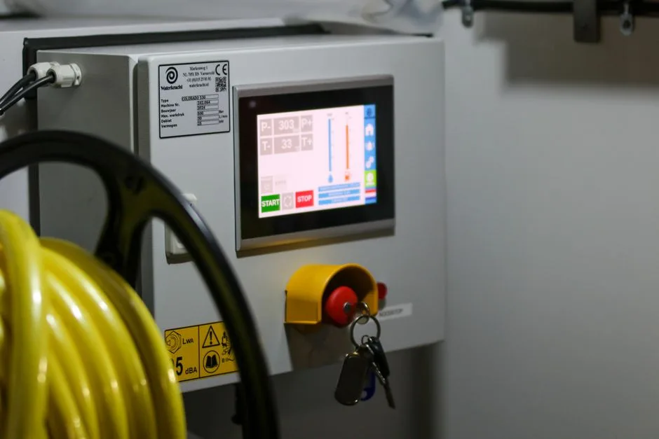 Close-up of an industrial control panel displaying safety features and a digital screen.